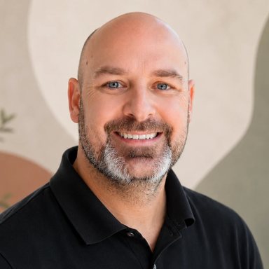 Ryan, founder of One Offer Forward, smiling in a black polo shirt